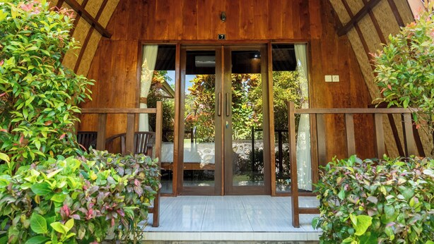 Ein Holzhaus mit großem Eingang und kleinem Balkon.