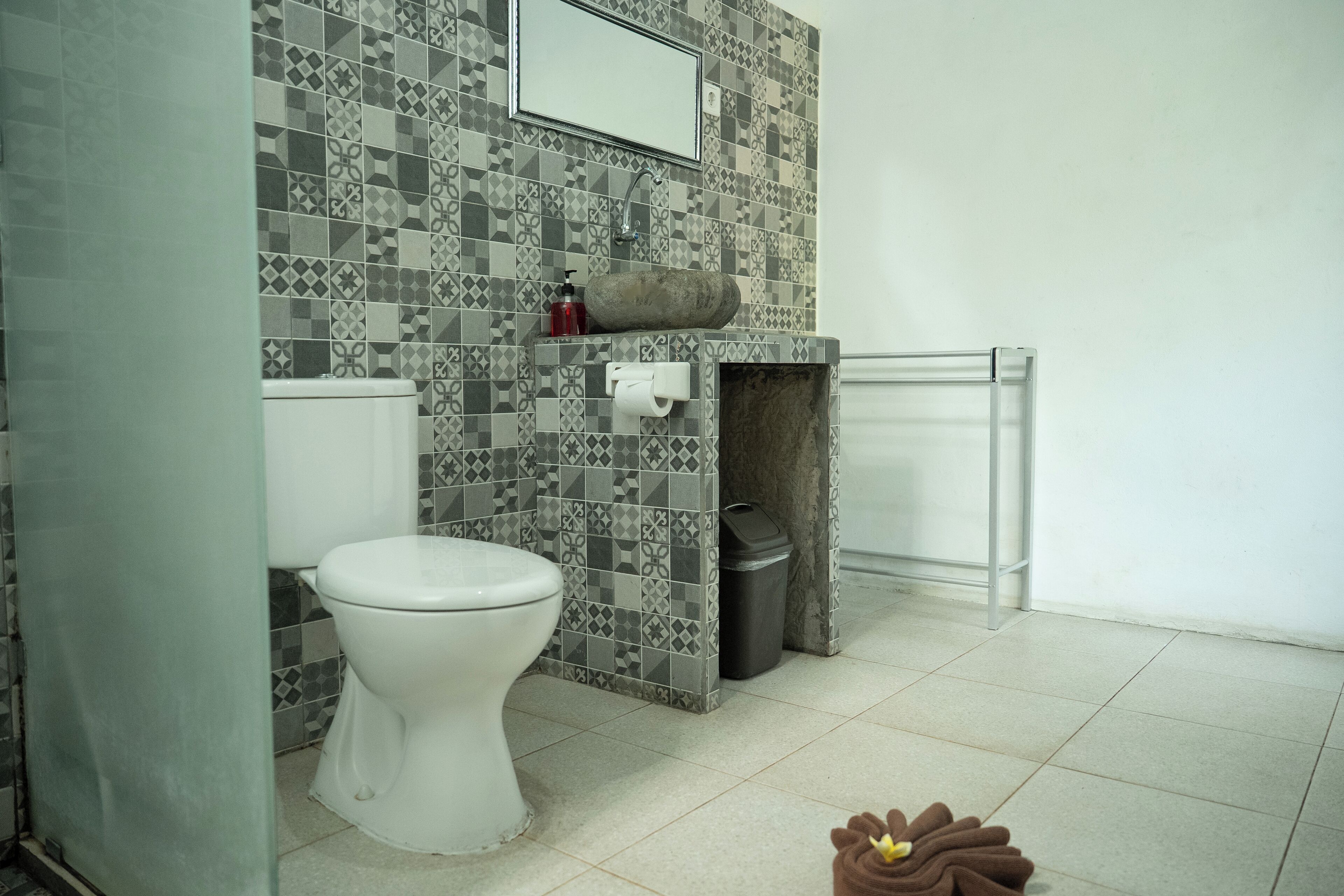 Un baño con inodoro, lavabo y cubo de basura.