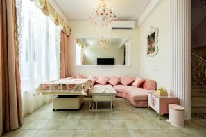 A room with a bed, a sofa, a small table, a mirror, and a chandelier. - Chunmanxiaozhu (Miaoli)