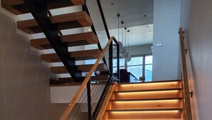 A staircase with wooden steps and a metal railing, leading to an upper floor. - Ski Out on Whitefish Mountain 3BD 4BA Sleeps 14+ Unbeatable SKI Location (Whitefish)