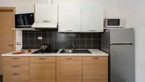 Eine moderne Küche mit Gasherd, Spüle, Mikrowelle und Kühlschrank.