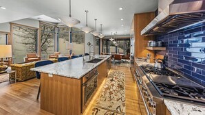 Una cocina moderna con una isla central, electrodomésticos de acero inoxidable y vistas al exterior.