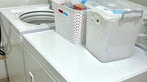 Una lavadora de carga frontal con un cesto y un dispensador de detergente en la parte superior.