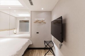 A hotel room with a bed, a TV mounted on the wall, a small seating area, and a window. - Banqiao-inn2 YaDong Branch (New Taipei City)
