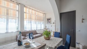 En matplats med ett bord dukat för två personer, en soffa och en krukväxt.