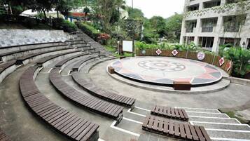 Un espacio de estar al aire libre con bancos y un elemento decorativo central.