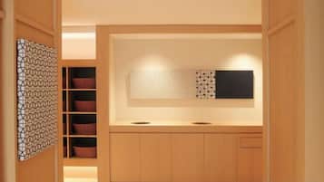 A modern kitchen with wooden cabinets, a countertop, and a wall-mounted light fixture.