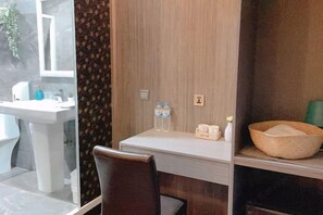 A bathroom with a sink, mirror, and toiletries. There is a wooden chair and a shelf with a basket and bottles. - Welove meworld Inn (Taipei)
