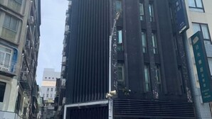 A tall building with a modern architectural design, featuring vertical lines and large windows. - Welove meworld Inn (Taipei)