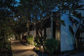 A pathway leading to a building with a covered entrance, surrounded by lush vegetation and illuminated by ambient lighting. - Shan Ban Bay By Riverinn (Pingtung)