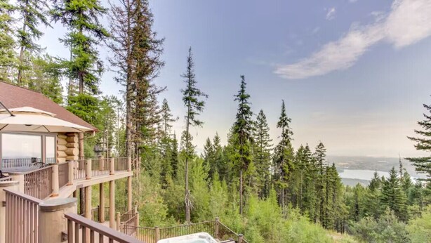 A cabin with a balcony overlooking a forest and a lake. - Alpine Ridge on Whitefish Mountain Sleeps 12 (Whitefish)