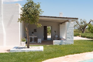 A white building with a covered patio, a small table, and a potted plant. - Villa Gia con Piscina Privata (San Michele Salentino)