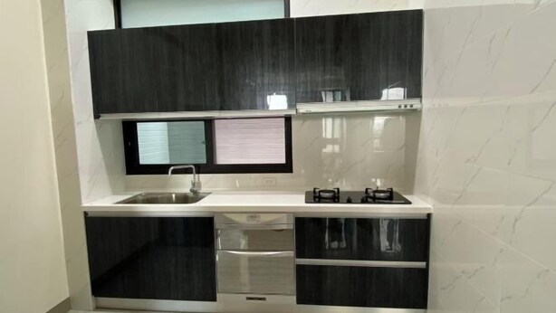 A modern kitchen with a built-in oven, a sink, and a window above the countertop. - Chien Chien Backpacker Hostel Business Hotel Accommodation Nankexin City Shanhua Yongkang (Tainan)