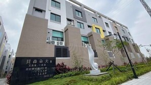 A modern building with a sign indicating it is a hotel. - Chien Chien Backpacker Hostel Business Hotel Accommodation Nankexin City Shanhua Yongkang (Tainan)
