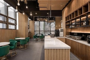 A modern interior with wooden paneling, round tables, and green chairs. - Island Hearth Kaohsiung (Kaohsiung)