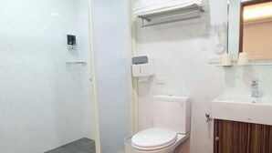 Un baño moderno con inodoro, cabina de ducha y tocador con espejo.