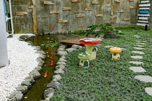 Un jardin agrémenté d’un petit étang, de pas japonais et de quelques bancs décoratifs.