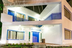 A two-story building with a balcony, a blue door, and a small outdoor seating area. - You Yue B&B (Hualien)