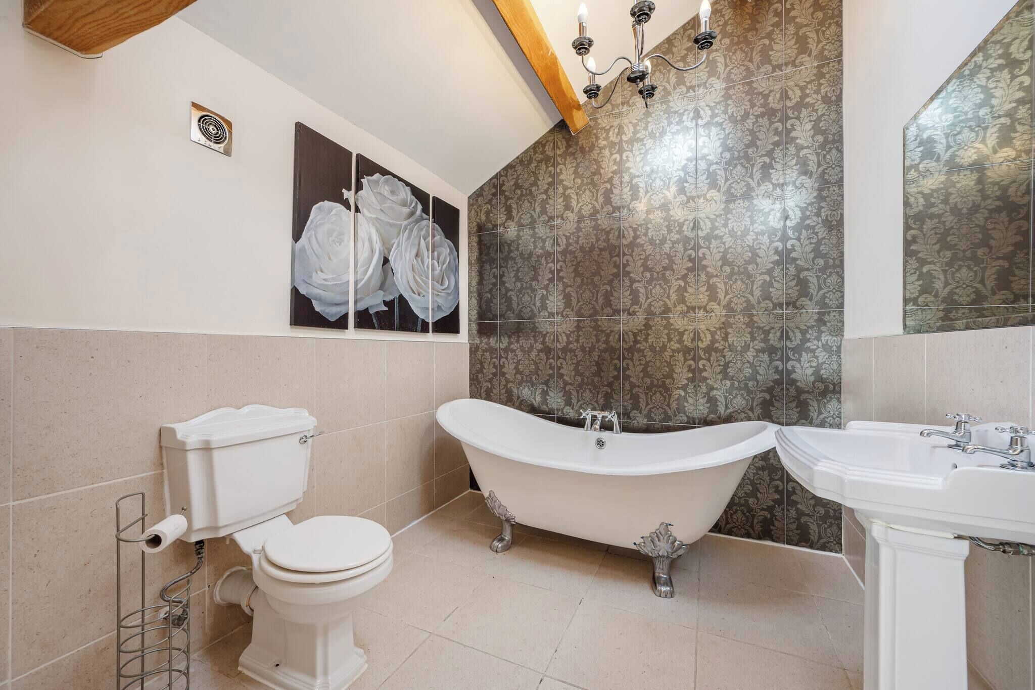 Une salle de bain avec une baignoire sur pieds, des toilettes et un lavabo.