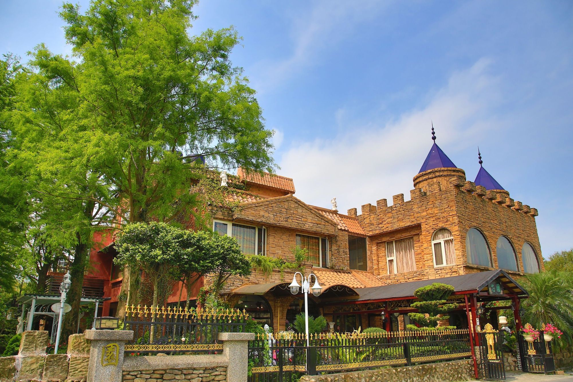 A castle-like building with a stone facade, arched windows, and a prominent tower with a pointed roof.