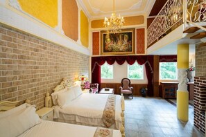 Une chambre d’hôtel avec un grand lit, un lustre, un tableau et une vue sur l’extérieur.