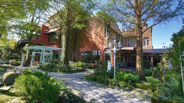Un jardín con un pabellón, un edificio de ladrillo y una construcción de piedra.