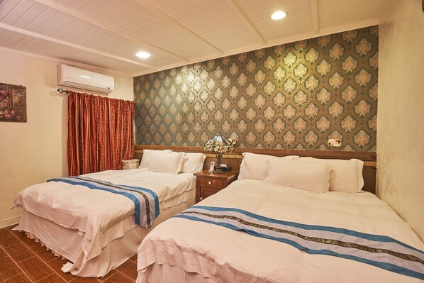 A hotel room with two beds, a nightstand, a lamp, and a patterned wallpaper. - Xinyuan My Dream Castle (Yilan)