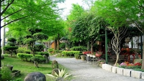 A garden pathway with various plants and a small table with chairs. - Xin Yuan-My Dream Castle (Yilan)