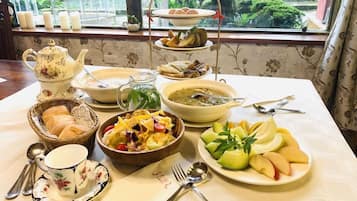 A table set with various dishes, a teapot, and a window view.