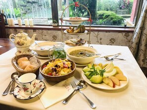 Une table dressée avec différents plats, une théière et une vue sur la fenêtre.