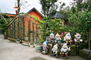 Ein Garten mit Zwergfiguren und einem schmiedeeisernen Tor.
