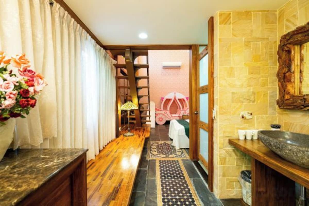 A hallway with a wooden floor, a rug, a sink, and a mirror on the right.