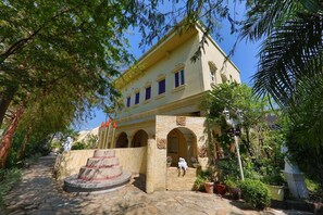 A building with a central courtyard, stone steps, and a statue. - Xinyuan My Dream Castle (Yilan)