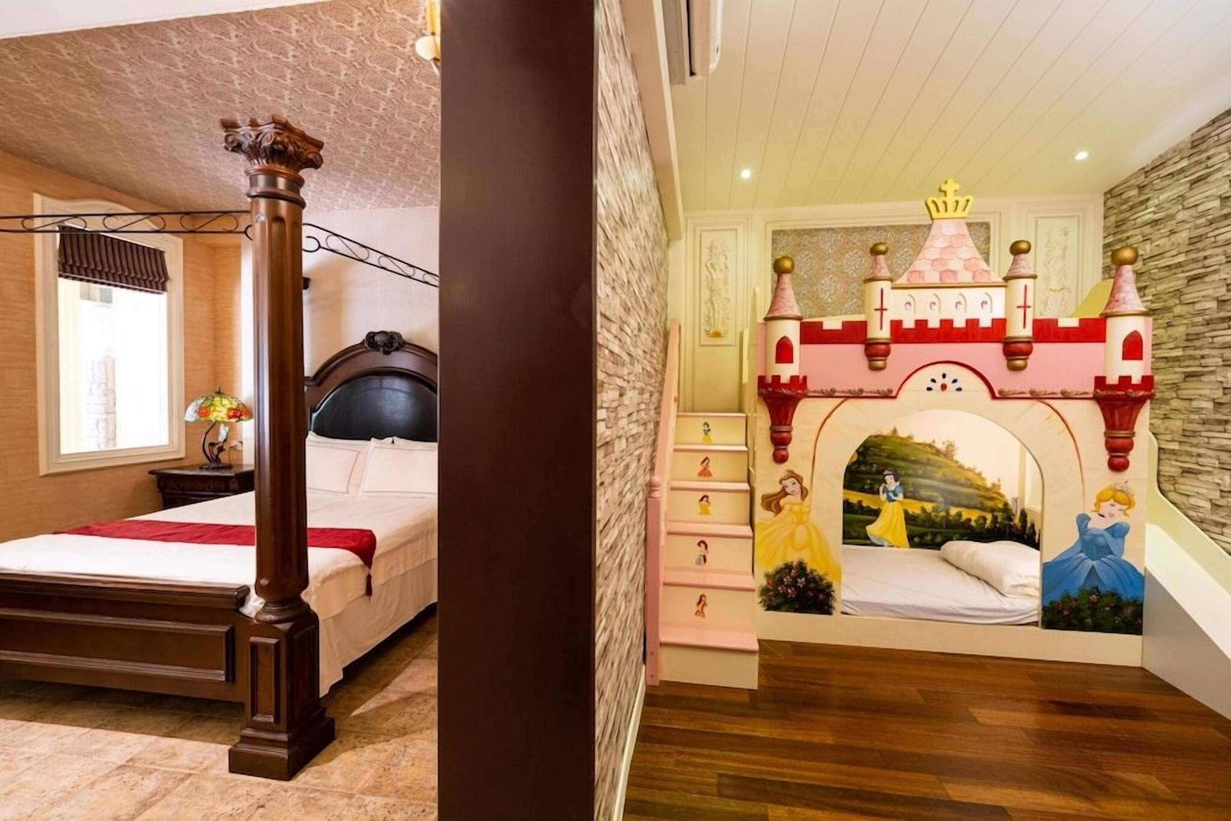 A bedroom with a large bed, a wooden chair, a fireplace, and a castle-themed wall mural.