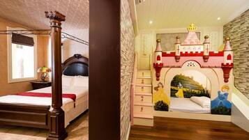 A bedroom with a large bed, a wooden chair, a fireplace, and a castle-themed wall mural.