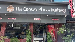Das Crown Plaza Heritage Hotel mit Schild für Tee & Kaffee und klimatisiertem Zimmer.