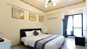 A bedroom with a bed, a desk, and a window with curtains. - Melinda Resort (Pingtung)