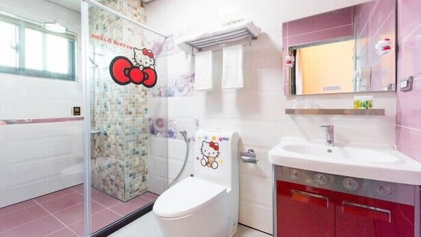 A bathroom with a toilet, a sink, and a mirror. - Melinda Resort (Pingtung)