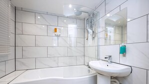 A modern bathroom with a bathtub, a sink, a shower, and a mirror. - Comfortable 4-bed Home With Free Parking Wales (Mountain Ash)