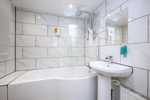 A modern bathroom with a bathtub, a sink, a shower, and a mirror. - Comfortable 4-bed Home With Free Parking Wales (Mountain Ash)