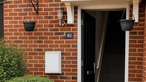 A brick building with a number '49' sign, a black door, a white mailbox, and a pathway leading to the entrance. - Reading Retreat 1 Bed With Private Parking (Reading)