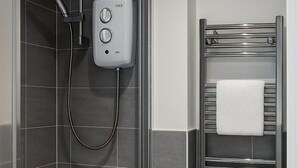 A modern bathroom with a shower, a sink, and a towel rack. - Reading Retreat 1 Bed With Private Parking (Reading)