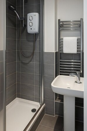 A modern bathroom with a shower, a sink, and a towel rack. - Reading Retreat 1 Bed With Private Parking (Reading)