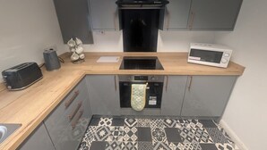 Une cuisine compacte équipée d’un four à micro-ondes, d’un grille-pain et d’un four traditionnel.