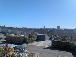 A residential area with terraced houses, a satellite dish, and a stone wall. - Comfortable 3 Bedroom House With Easy City Access (Swansea)