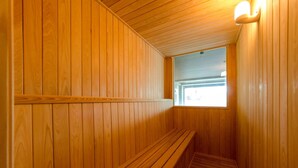 Interior de madeira com um banco e uma pequena janela.