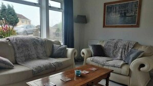 A living room with two beige sofas, a wooden coffee table, and a framed picture on the wall.