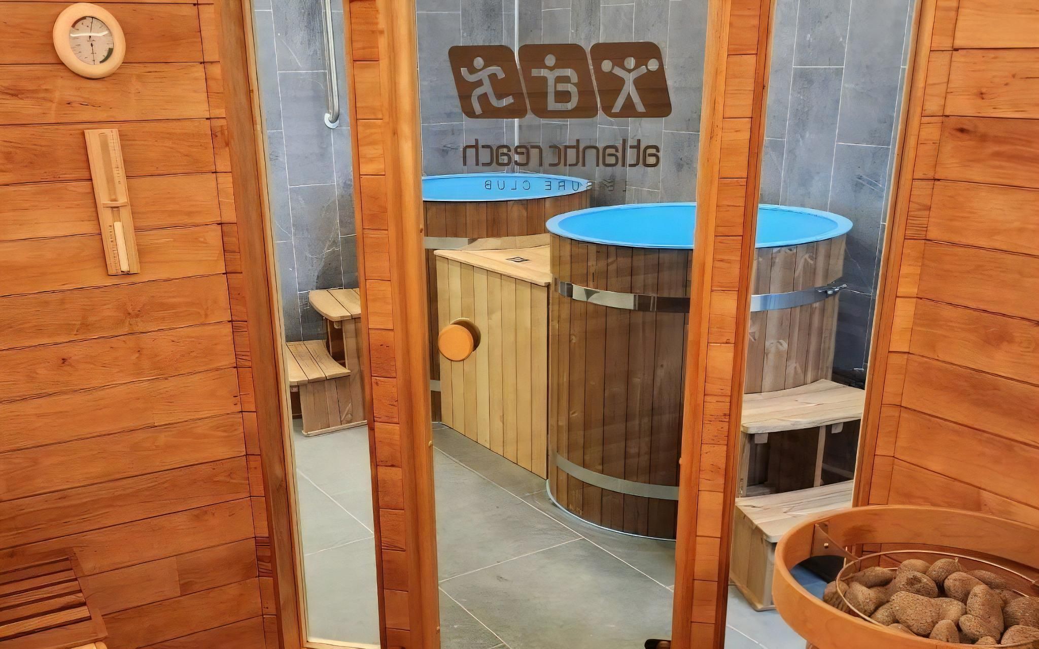 Un espai de sauna amb parets de fusta, una banyera d'hidromassatge blava i una cadira de fusta.