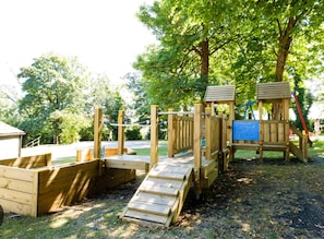 A wooden playground with a slide and climbing structures. - Atlantic Reach Cosy 2-bed With Parking (St. Columb Major)
