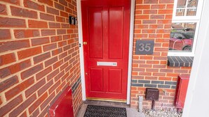 A red door with a number 35 sign on the wall beside it.